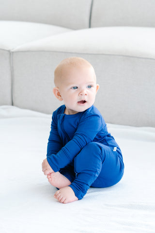Sitting baby wearing bamboo zip romper in neptune